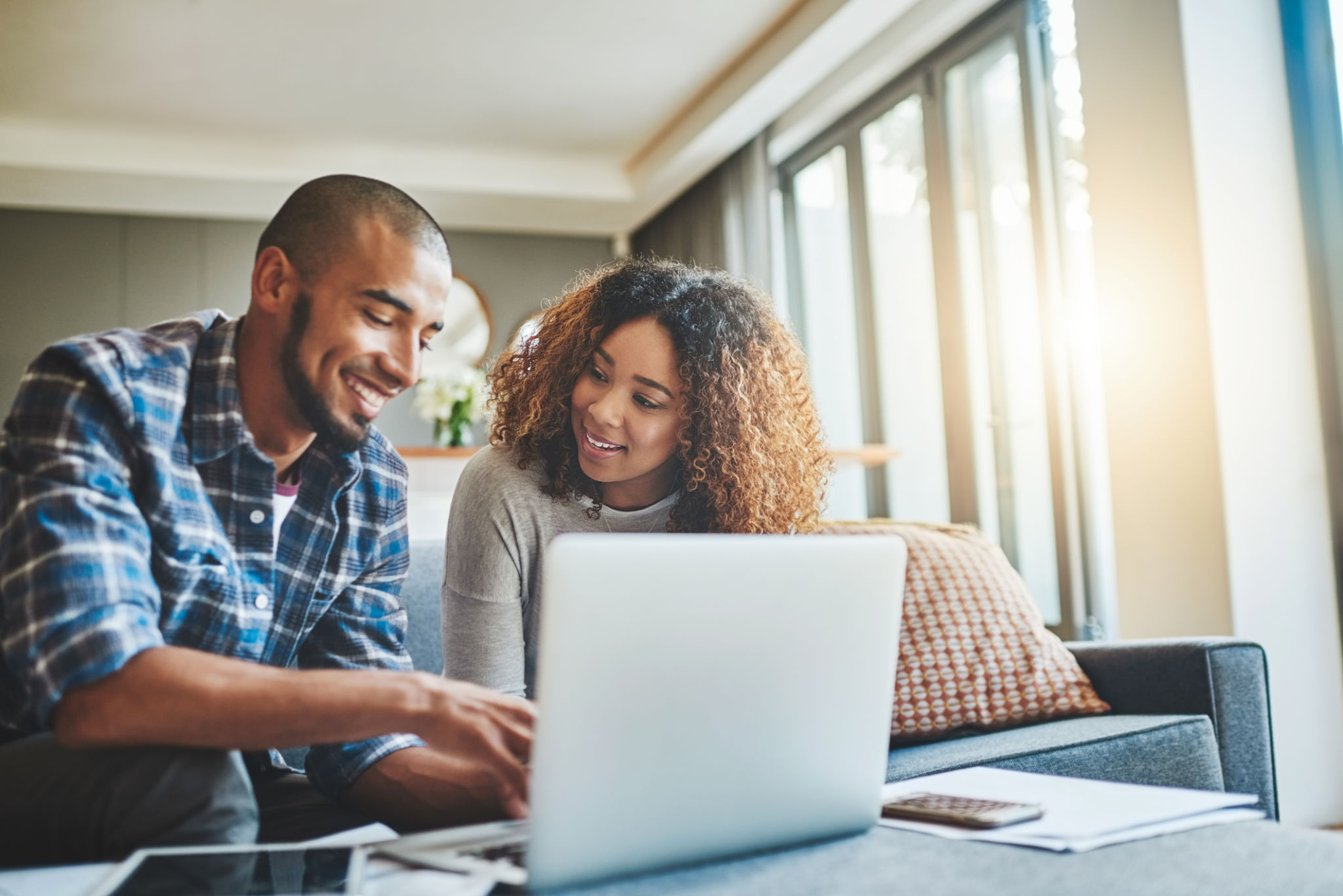 Shot of a young couple using a laptop while working on their home finances Shot of a young couple using a laptop while working on their home finances