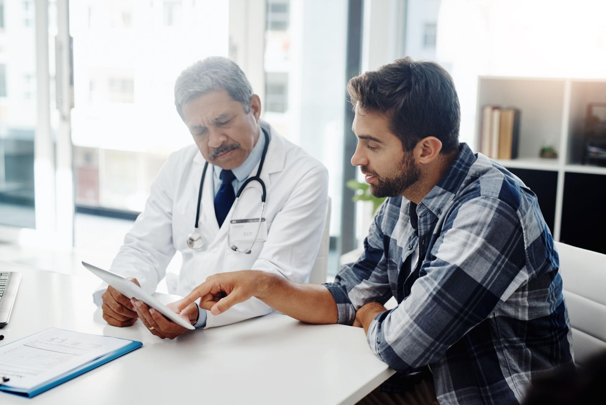 Cropped shot of a mature male doctor and patient having a discussion in the doctor's office before a checkup